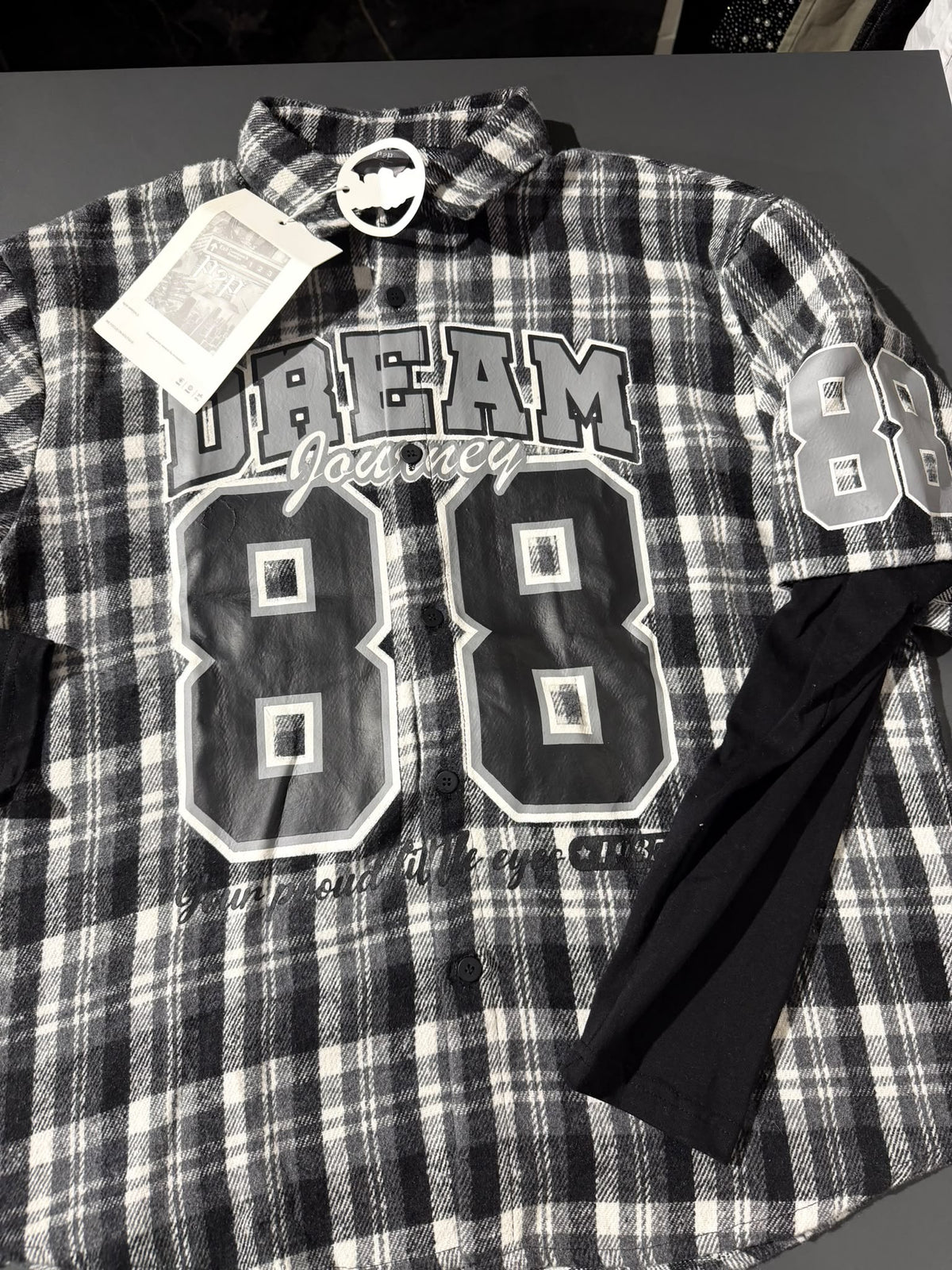 Camicia a quadri bianca nera e grigia con stampa "Dream Journey 88" e maniche nere effetto layered | Christian Store