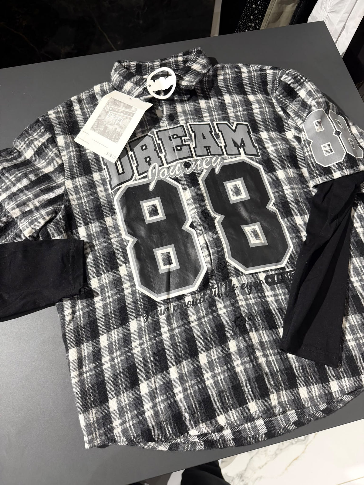Camicia a quadri bianca nera e grigia con stampa "Dream Journey 88" e maniche nere effetto layered | Christian Store